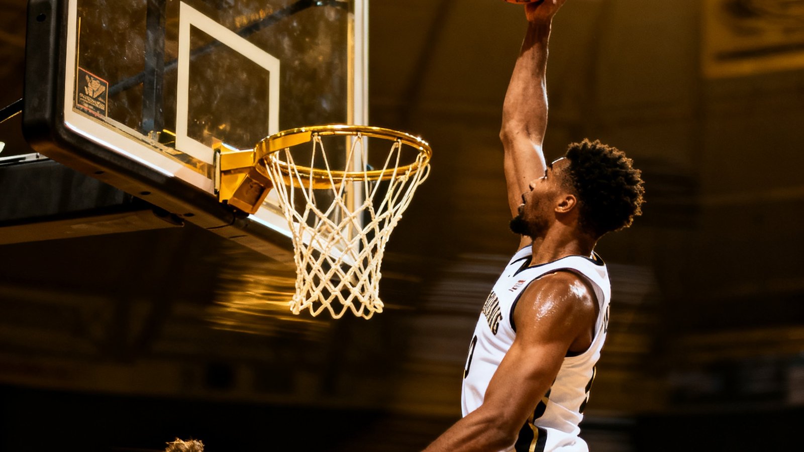 NBA比赛中一次精彩的空中接力扣篮瞬间，一名球员高高跃起双手接球暴扣，防守球员仰头无奈观望，篮筐因冲击力微微震颤，计时器显示还剩0.8秒